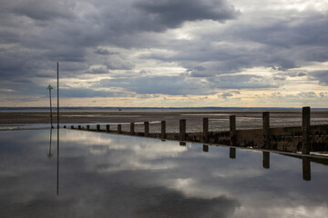 Fototapeta na wymiar Moody reflections on Chalkwell Beach, near Southend-on-Sea, Essex, England, United Kingdom