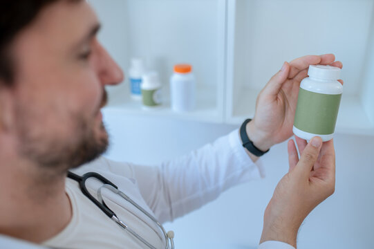 Doctor reading the label on a dietary supplement