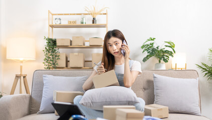 E-commerce businessman is talking on the phone with a customer who comes in to inquire and place her order, Woman writes mailbox address in preparation for delivery, SME entrepreneur, Packing box.