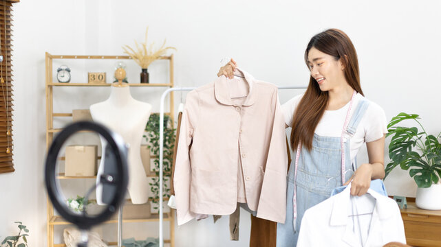 Beautiful woman with social media influences performing live or recording shows selling cheap fashion clothes in her studio, Recording vlog video live streaming, Online fashion clothing business.