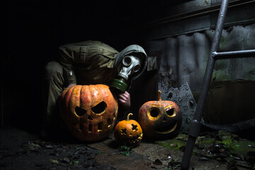 a man in a gas mask with orange halloween pumpkins celebrates the holiday