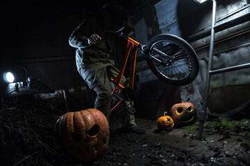 a man in a gas mask with orange halloween pumpkins celebrates the holiday