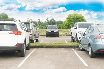 Car parked in asphalt parking lot and one empty space parking  in nature with white clouds and blue...