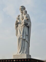 Fototapeta na wymiar statue of a father of a church holding a baby boy