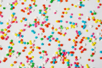 Multi-colored sugar small stars for sprinkling sweets on a white background. Isolated