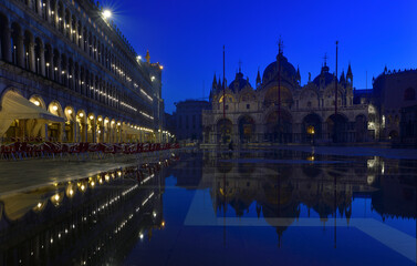 Fototapeta na wymiar Der Markusplatz in Venedig zur Blauen Stunde am frühen Morgen und im nächtlichen Hochwasser spiegelt sich der Markusdom