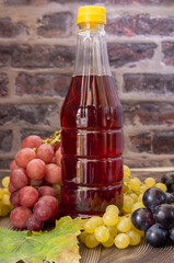 cider vinegar in bottle, dark wooden background, selective focus