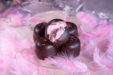 Sponge marshmallow candy covered in chocolate and vanilla wafer underneath, on a pink background.