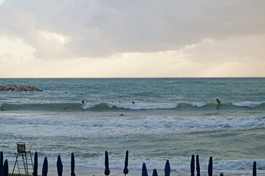 Surfisti fra le onde del mare al tramonto nel golfo di Levanto, Cinque Terre, Liguria, Italia
