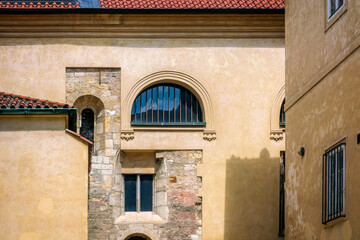 External view of the walls of the courtyard with windows of various configurations.