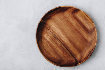 Wooden plate. Empty wooden plate, plate on gray stone concrete background, top view.