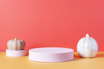 Empty product podium with Halloween pumpkin decor in pastel pink and orange colors