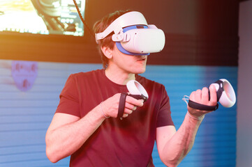 vr game and virtual reality. man gamer fun playing on futuristic simulation video shooting or explore study game in 3d glasses and joysticks in entertainment vr room with innovation technology. flare