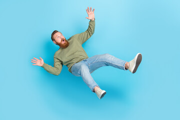 Full size photo of handsome young man frightened falling down slipping dressed stylish khaki outfit...