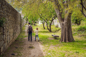 Obraz premium Dad and son tourists walks through the old town of Bar in Montenegro. Happy tourist walks in the mountains. Suburbs of the city of Bar, Montenegro, Balkans. Beautiful nature and landscape