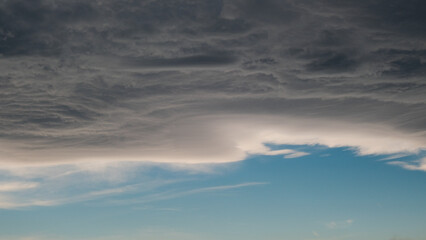 cloudy scary sky, pale white blue sky with scattered cumulus clouds before rain. A gray-blue cloud is moved by a wind current, clouds before rain. cloud background, gray-blue color