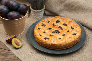 shortcake with plums on a wooden table. the concept of homemade shortcrust pastry. baked fruit dessert on the kitchen table close up