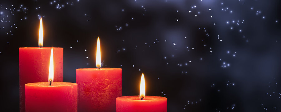 four red burning candlelights in front of the sparkling night sky, greeting card for holidays with copy space