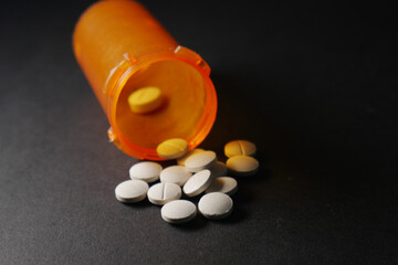 opioid medical pills spilling on black background 