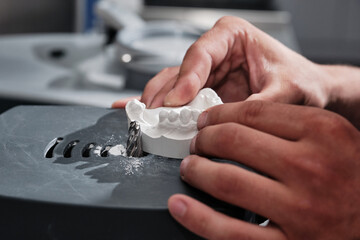 Trim the dental arch with a dental arch trimmer. Workplace dental technician.