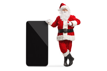 Santa claus leaning on a big mobile phone and pointing