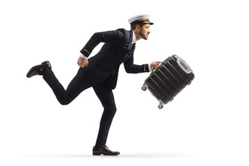 Full length profile shot of a pilot in a rush carrying a suitcase and running © Ljupco Smokovski