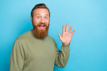 Photo of sincere optimistic positive guy with ginger hairdo wear khaki long sleeve waving palm say...