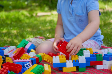 child plays with colored blocks,a child and toys, a child builds a house from a constructor
