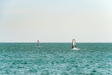 extreme man athlete swims on the wind surf on the sea wave against the blue sea and the horizon....
