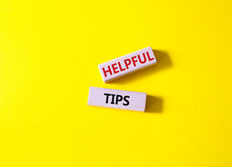 Helpful tips symbol. Wooden blocks with words Helpful tips. Beautiful yellow background. Business and Helpful tips concept. Copy space.
