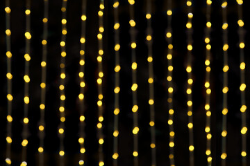 Abstract Christmas lights on black background. Glowing light bulb garland,