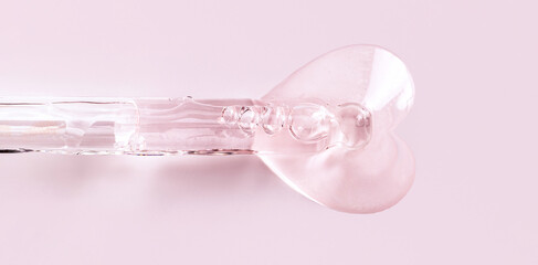banner pipette with serum drop in the shape of a heart on a pink background