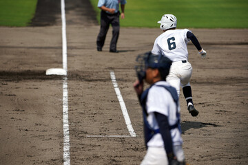 ヒットを打ち一塁へ向かうバッター（高校野球）