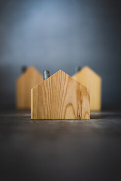 Group of three model houses on gray background real estate literary concept 