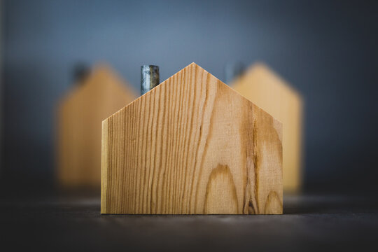Group of wooden houses focused on foreground against gray background real estate concept