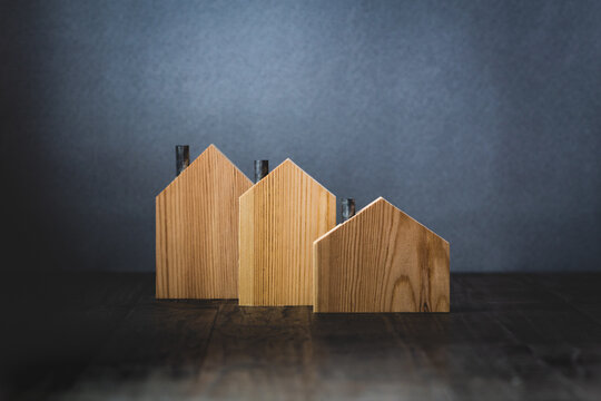 Group on three wooden model houses on gray background real estate graphic concept