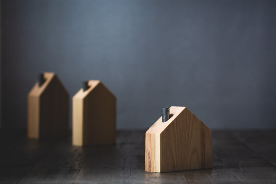 Hopeful wooden house isolated from other homes against gray background conceptual image