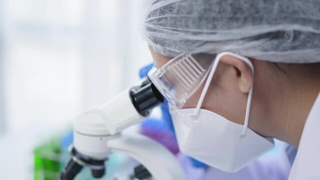Female scientist is working and using microscope in laboratory and biology laboratory for develop and analysis virus vaccine and medicine.