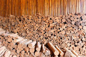 Stacked firewood eucalyptus wood logs and cut texture for rustic style background brown tones