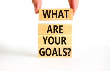 What are your goals symbol. Concept words What are your goals on wooden blocks. Beautiful white table white background. Businessman hand. Business psychological what are your goals concept. Copy space