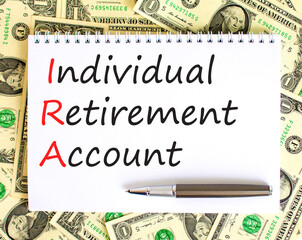IRA individual retirement account symbol. Concept words IRA individual retirement account on white note on background from dollar bills. Business IRA individual retirement account concept. Copy space
