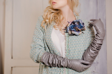 A woman in a tweed jacket with long leather gloves