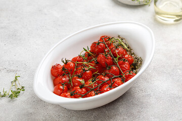 Dish with Baked mini cherry tomatoes with oil, garlic and thyme. Diet dinner idea. Vegetable, vegan.