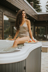 Young woman enjoying in outdoor hot tub on vacation