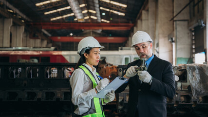 Professional Engineers are on duty, discussing, inspecting, and maintaining the machine in the train garage that is malfunctioning.