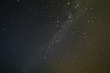 Deep night sky with many stars and forest and sea