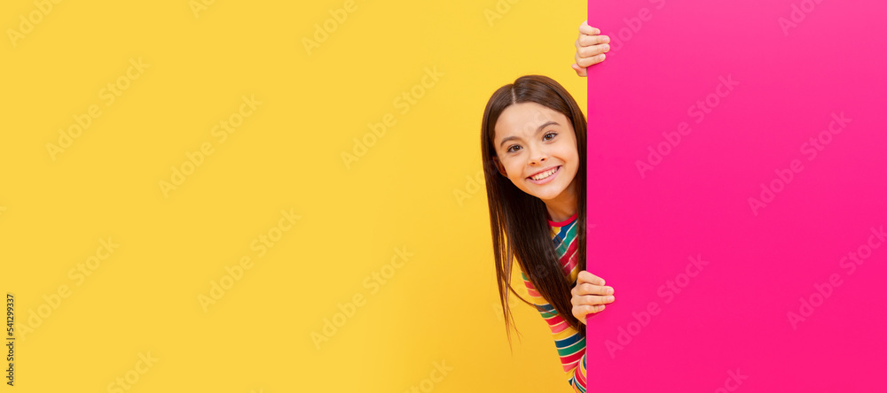 Poster happy teenager girl behind pink paper sheet with empty place for copy space, advertising. child face