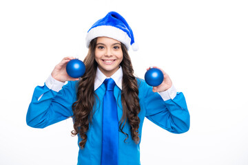 Christmas, New Year kids celebration concept. Portrait a teenage girl child in blue santa hat hold christmas ball, shirt and necktie isolated on white background, copy space.