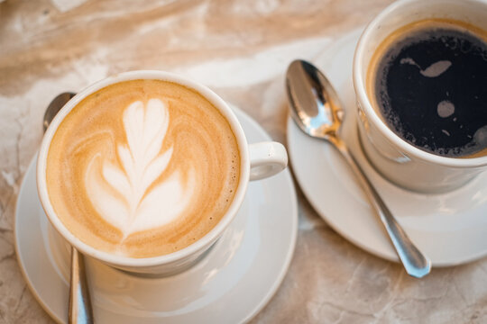 atte art milk coffee and black espresso coffee top view.  caffeine drink on marble table .