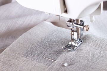 Modern sewing machine presser foot with linen fabric and thread, closeup, copy space. Sewing...